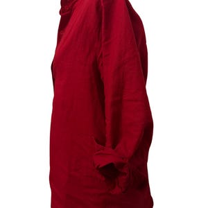 K&ouml;nnte beinhalten: Ein lang&auml;rmliges, rotes Button-Down-Hemd mit R&uuml;schenkragen. Das Hemd ist aus einem strukturierten Stoff gefertigt und hat hochgekrempelte &Auml;rmel. Das Hemd wird auf einer Schaufensterpuppe pr&auml;sentiert.