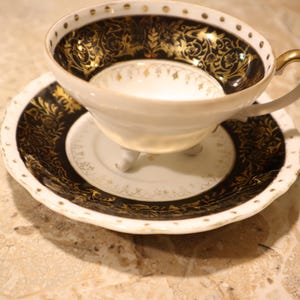 Vintage Porcelain 3-Footed Teacup and Saucer made in Japan Black and Gold on Cream Design