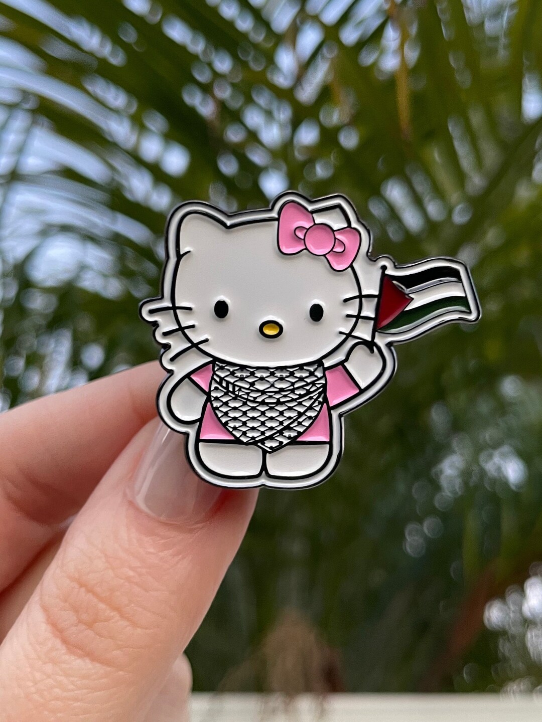 国旗を掲げてクーフィーヤをかぶったファラスティニのハローキティピン