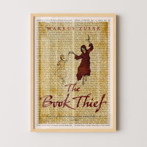 May include: A framed art print featuring the book title "The Book Thief" in a stylized font. The artwork includes illustrations of figures and text from the book, with the author's name, Markus Zusak, displayed prominently.