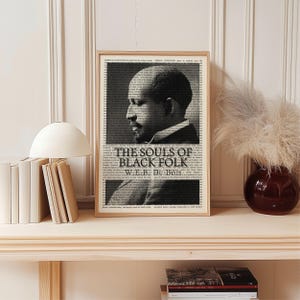 May include: A framed black and white print featuring a portrait of W.E.B. Du Bois in profile. The print includes the title "The Souls of Black Folk" and is set against a background of printed text.