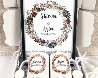 May include: A gift box set with a framed print featuring a watercolor wreath with the names Shirina & Azim and the date 27-04-2024. The text "And we created you in pairs 78.8" is at the top of the print. The box also contains two white mugs with the names Shirina and Azim and the date 24/02/2024 printed on them.
