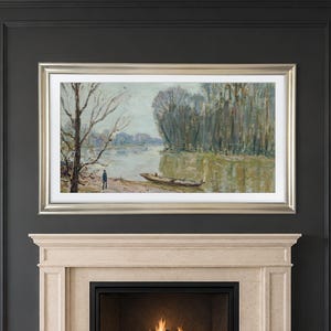 May include: A landscape painting in a silver frame depicting a river scene with a small boat moored near the bank, a solitary figure standing on the shore, and dense trees under a muted, overcast sky, mounted above a stone fireplace.