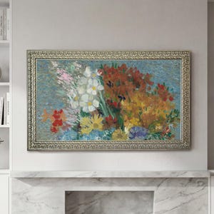 May include: A framed floral painting featuring a vibrant bouquet of flowers. The artwork showcases white, yellow, red, and blue blooms against a light blue background. The ornate gold frame adds a touch of elegance to the piece, suitable for home decor.