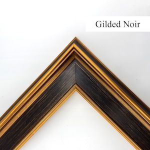 May include: A corner section of a picture frame with a gold and black design. The frame has a gold inner and outer edge, with a black centre section. The text "Gilded Noir" is in a white rectangle in the upper right corner.