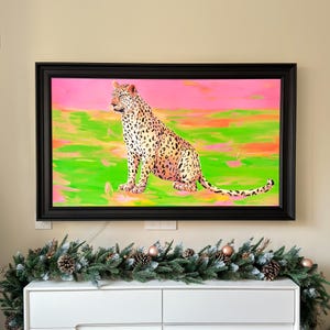 May include: A framed painting of a leopard sitting in a field with a pink and green background.