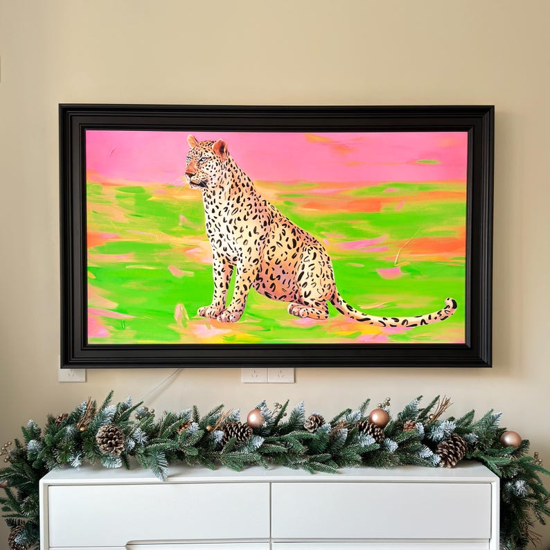 May include: A framed painting of a leopard sitting in a field with a pink and green background.