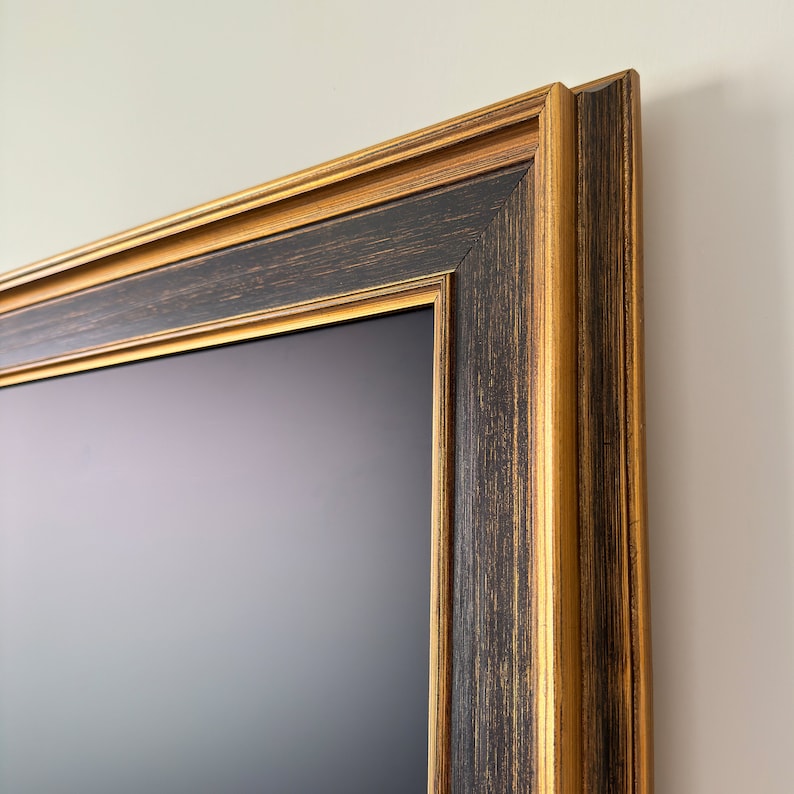 May include: A black picture frame with a gold trim. The frame is made of wood and has a distressed finish.