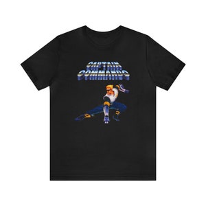 May include: Black t-shirt featuring a retro video game character and the text "CAPTAIN COMMANDOS" in a blue and silver gradient.