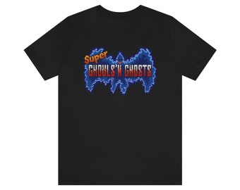 Puede incluir: Camiseta negra con un gráfico azul y rojo de un murciélago con el texto "Super Ghouls 'n Ghosts" en naranja y rojo.
