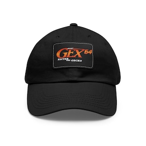 Puede incluir: Gorra de béisbol negra con un parche cuadrado que muestra el texto "GEX 64 ENTER THE GECKO" en naranja y blanco.