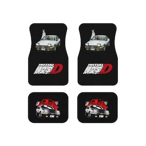 May include: Set of four black car floor mats featuring designs from the anime series Initial D. The top mats show a white car with a person standing next to it. The bottom mats show a red and black car.