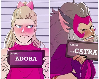 Könnte beinhalten: Zwei Frauen in rosa und lila Outfits halten Haftbefehlsfotos hoch. Das Schild links sagt "KoSPD ADORA" und das Schild rechts sagt "KoSPD und CATRA".