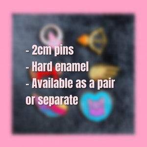 May include: A set of two enamel pins featuring a rainbow heart and a blue heart with a cat face. The pins are 2 cm in size and are available as a pair or separately.  - 2cm pins - Hard enamel - Available as a pair or separate