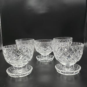 May include: Set of six clear crystal dessert bowls with diamond-cut patterns. Each bowl sits on a matching round base. The bowls have a classic, elegant design, perfect for serving ice cream or other treats.