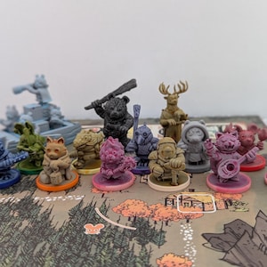 May include: A set of 12 colorful miniature figurines, each with a unique design and pose. The figurines are made of plastic and are about 2 inches tall. They are arranged on a game board with a forest scene.