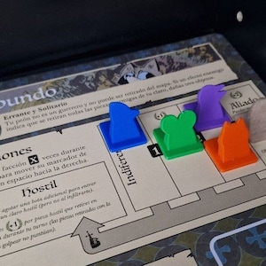May include: A board game with a blue, green, orange, and purple game pieces. The game pieces are on a board with the text "El Vagabundo" and "Relaciones".