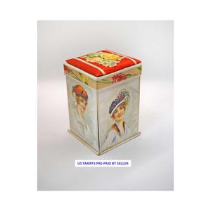 Pode incluir: Uma caixa quadrada vintage com uma parte superior vermelha com estampa floral e laterais com ilustrações de mulheres com chapéus. A caixa tem um fundo creme e o texto "US TARIFFS PRE-PAID BY SELLER" é impresso na parte inferior.