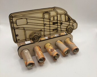 Könnte beinhalten: Ein hellbrauner Geldhalter aus Holz in Form eines Wohnmobils mit fünf Schlitzen, die gerollte Banknoten enthalten. Das Wohnmobil hat geätzte Details. Die Banknoten sind sichtbar, was auf ein Reise- oder Sparthema hindeutet.