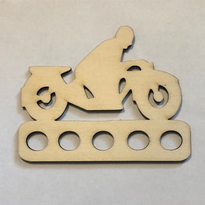 Peut inclure: Mod&egrave;le de moto en bois avec six trous pour tenir les aiguilles &agrave; tricoter. La moto est de style silhouette et est en bois brun clair.