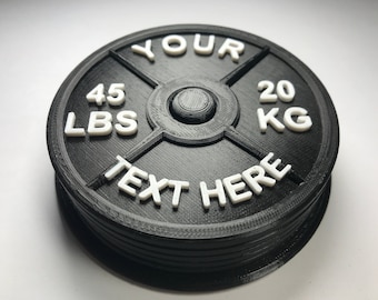 Puede incluir: Placa de peso negra con texto blanco que dice "YOUR TEXT HERE", "45 LBS" y "20 KG".