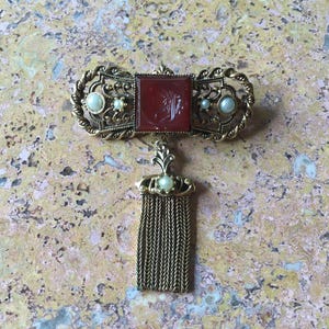 Vintage Filigree Brooch with Fringe Tassel and Carnelian Stone. 2” x 2.5” Overall. Tassel Length 1.5”. In Excellent Vintage Condition.