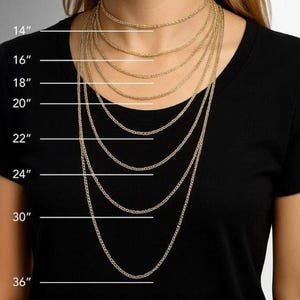 Könnte beinhalten: Eine Person trägt ein schwarzes T-Shirt mit mehreren goldfarbenen Kettenhalsketten unterschiedlicher Länge. Die Halsketten haben eine Länge von 35,5 cm bis 91,4 cm, wobei die Maße neben jeder Kette deutlich angegeben sind.