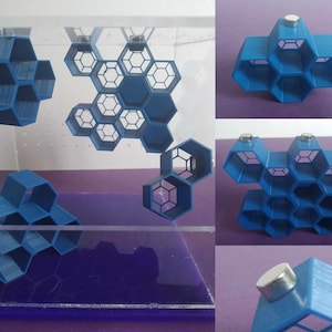 May include: A set of blue 3D printed honeycomb shelves with magnets attached to the back. The shelves are arranged in different configurations, some hanging from the ceiling and others sitting on a surface.