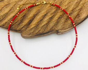 Minimalistische kralenketting in rood en goud of zilver, ingetogen en elegante stijl, tijdloos en subtiel, verstelbare choker