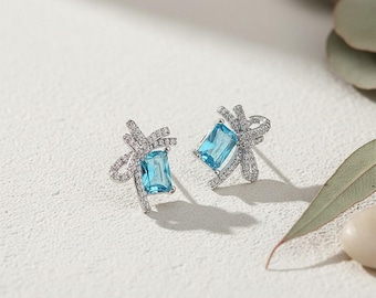 Pendientes delicados de lazo bañados en plata con circonita azul aguamarina para un estilo playero ideal para vacaciones.