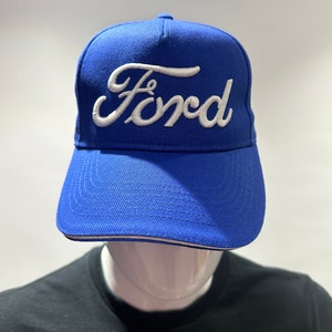 May include: A blue baseball cap with a white embroidered Ford logo.