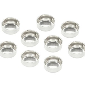 May include: Ten small, silver-coloured metal bezel cups are displayed. Each cup has a rounded base and a slightly raised rim. They are presented on a white background, ideal for jewellery making or crafting projects.