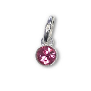 May include: A small, round, pink gemstone charm with a faceted surface, set in a silver-colored metal bezel. The charm has a loop at the top for attaching to a necklace or bracelet. The background is plain white.