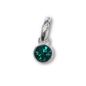 May include: A small, round, emerald green gemstone pendant with a silver-colored bail. The gemstone is set in a silver bezel and has multiple facets. The bail has a small, clear accent stone. This pendant is suitable for necklaces or bracelets.