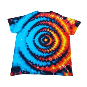 May include: A tie-dye t-shirt with a blue, black, orange and yellow spiral design.
