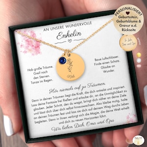 May include: Gold necklace with a circular pendant, a blue gemstone, and a floral engraving. The pendant is inscribed with the name "Nele". The necklace is displayed in a black box with German text.