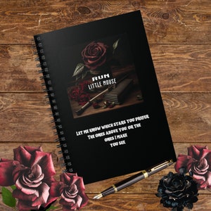 May include: Black spiral notebook with a dark red rose and a quote that reads "RUN LITTLE MOUSE LET ME KNOW WHICH STARS YOU PREFER THE ONES ABOVE YOU, OR THE ONES I MAKE YOU SEE"