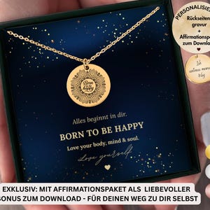 Könnte beinhalten: Eine goldfarbene Halskette mit einem runden Anhänger mit der Aufschrift "Born to be Happy" in einer dekorativen Schriftart. Der Anhänger hängt an einer zarten Kette. Die Halskette wird in einer dunkelblauen Schachtel mit dem Text "Born to be Happy" präsentiert.