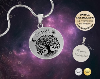 May include: A silver necklace with a round pendant featuring a black tree of life design with hearts, stars, a moon, and a sun. The back of the pendant can be engraved with a personalized message. The necklace is shown against a purple and black galaxy background.