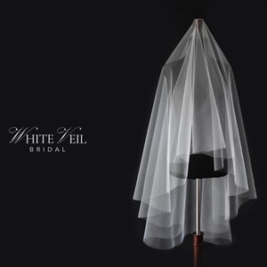 May include: A sheer white bridal veil draped over a mannequin, featuring multiple layers of soft tulle fabric. The text White Veil BRIDAL is printed in white on the left side against a solid black background, creating a clear visual contrast.