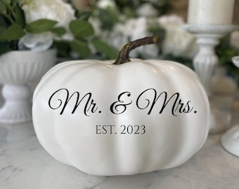 May include: White ceramic pumpkin with black lettering that reads "Mr. & Mrs. EST. 2023".