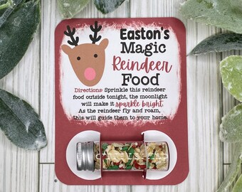 May include: A red and white card with a cartoon reindeer and the text "Easton's Magic Reindeer Food". Directions are printed on the card: "Sprinkle this reindeer food outside tonight, the moonlight will make it sparkle bright. As the reindeer fly and roam, this will guide them to your home." A small clear tube filled with colorful sprinkles is attached to the card.