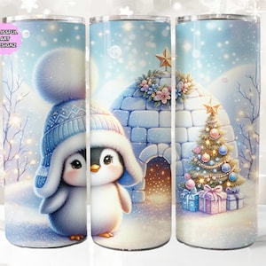 May include: A winter-themed tumbler featuring a cute penguin wearing a blue hat and scarf, standing in front of a snow-covered igloo and a decorated Christmas tree. The background is a light blue sky with snowflakes.
