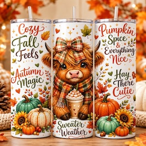 May include: Three cylindrical tumblers with straws featuring a Highland cow wearing a plaid bow and scarf, holding a coffee cup. The design includes pumpkins, sunflowers, autumn leaves, and text reading Cozy Fall Feels, Autumn Magic, and Pumpkin Spice.