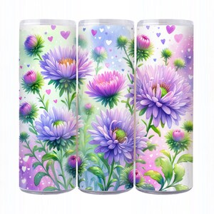 Op de afbeelding: Drie 20 oz. roestvrijstalen bekers met een bloemenmotief. De bekers hebben een aquarel achtergrond met paarse en roze bloemen en harten.