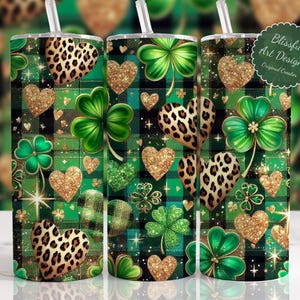 May include: Tumblers with a St. Patrick's Day theme. The design features a green and black plaid pattern, gold glitter hearts, leopard print hearts, and green shamrocks. The tumblers have a straw and the text "Blissful Art Designz Original Creator".