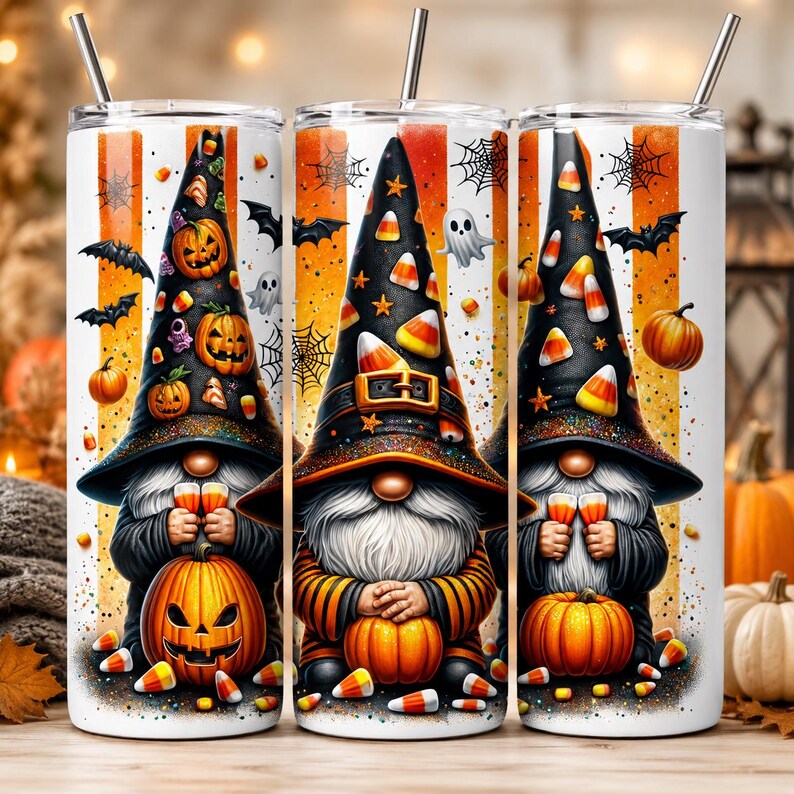 May include: Three Halloween-themed tumblers with a gnome design. Each tumbler features a gnome wearing a witch hat adorned with candy corn and holding a drink. The design includes pumpkins, bats, and spiderwebs against a striped orange and white background.