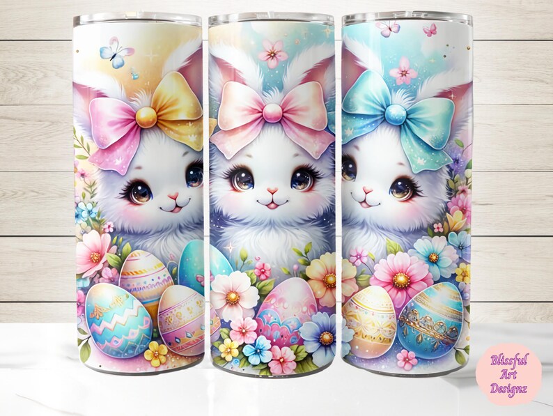 May include: Three white Easter bunny tumblers with colorful bows and Easter eggs. The tumblers are decorated with pastel flowers and butterflies.