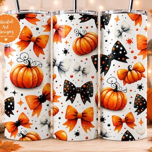 May include: A cylindrical tumbler featuring a white background with a repeating pattern of orange pumpkins and bows in orange, black, and white. The design includes small black dots and star shapes. A logo reads Blissful Art Designz Original Creator.