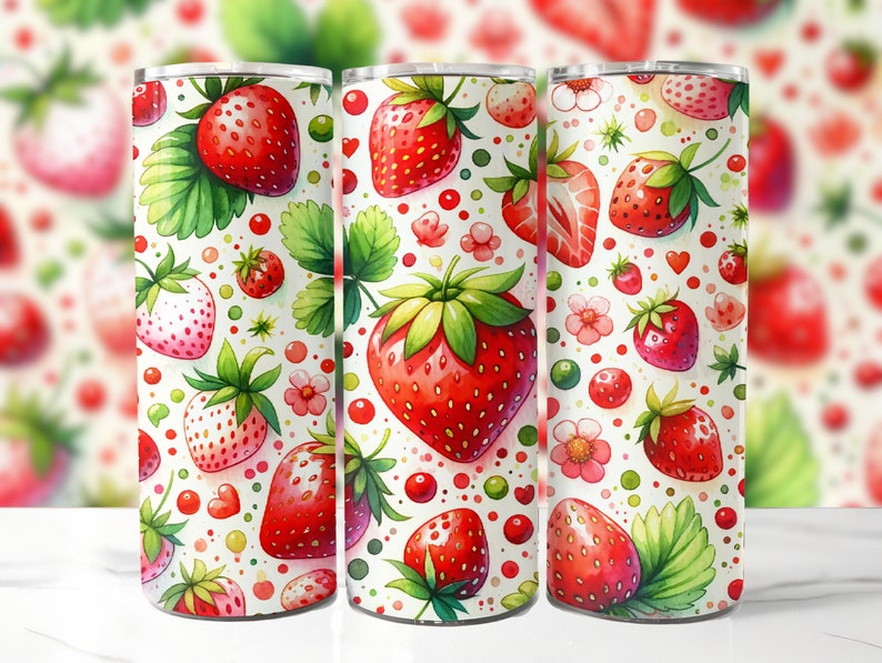 May include: A white tumbler with a red and green strawberry pattern. The tumbler is made of stainless steel and has a double-walled design to keep drinks cold or hot.